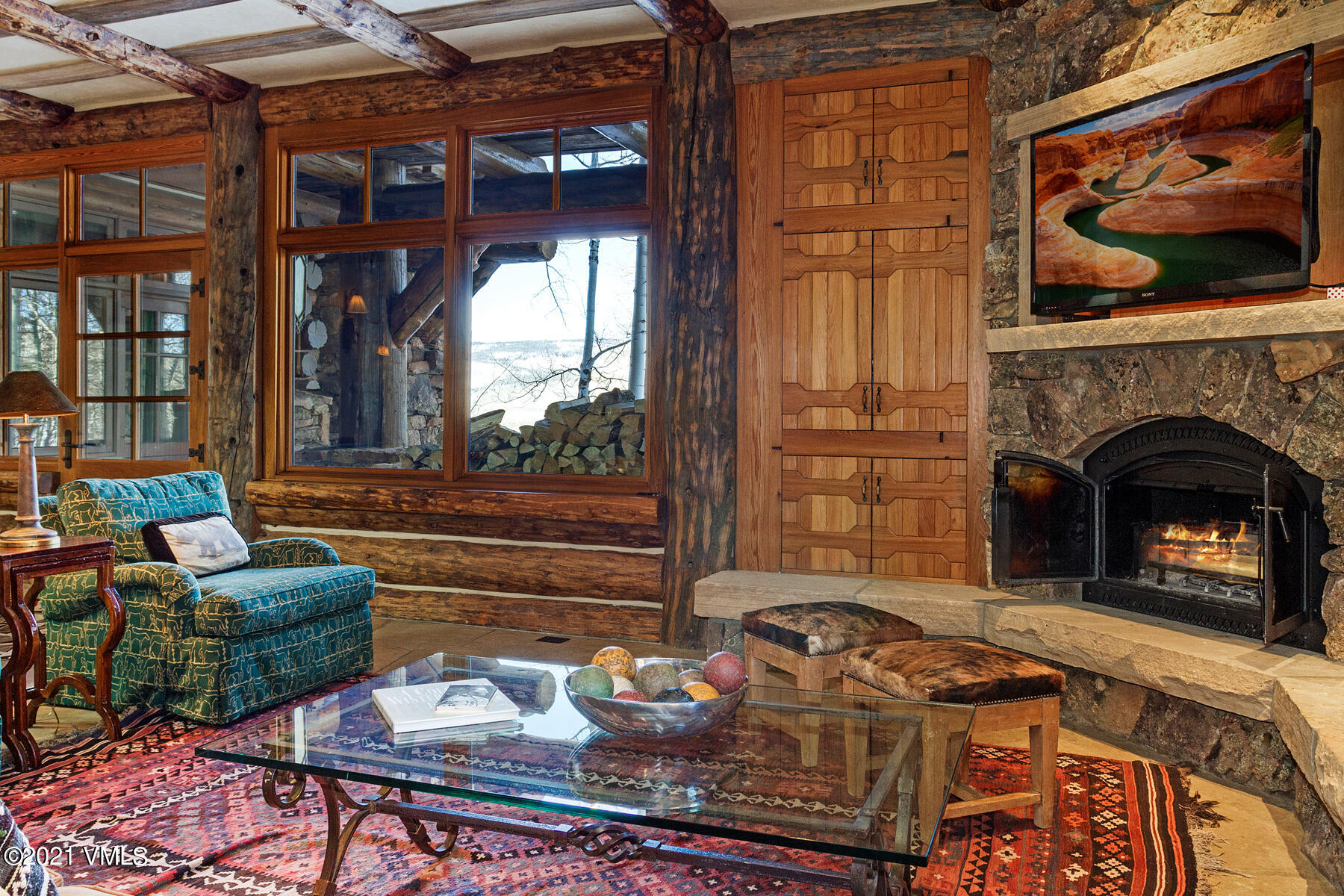 2291 Daybreak Ridge Road Avon, CO 81620 - Photo 34 of 56 a living room with furniture a fireplace and a floor to ceiling window
