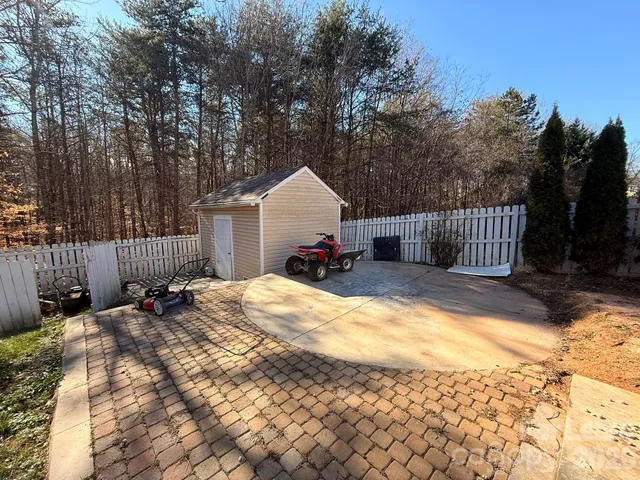 a view of a house with a yard and wooden fence