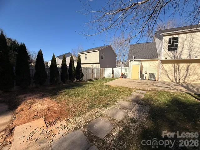 a view of a house with backyard and trees