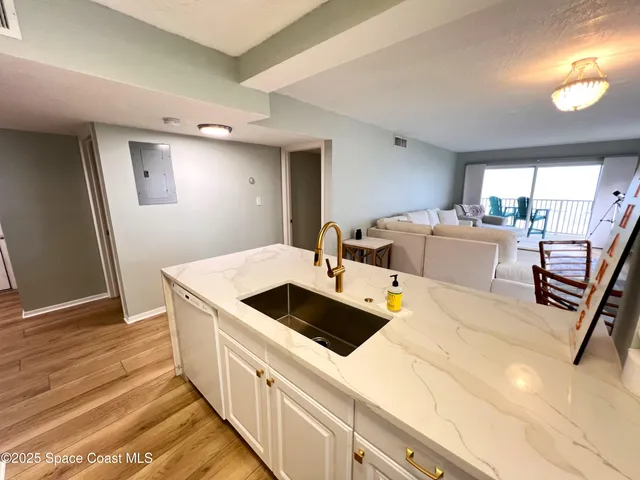 a kitchen with stainless steel appliances kitchen island granite countertop a sink and wooden floors