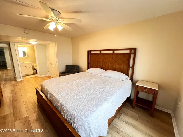 a spacious bedroom with a bed and a chandelier