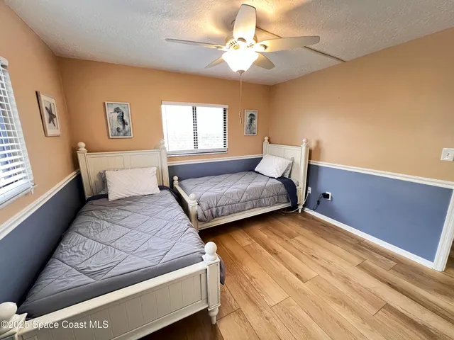 a bedroom with a bed chandelier and a window