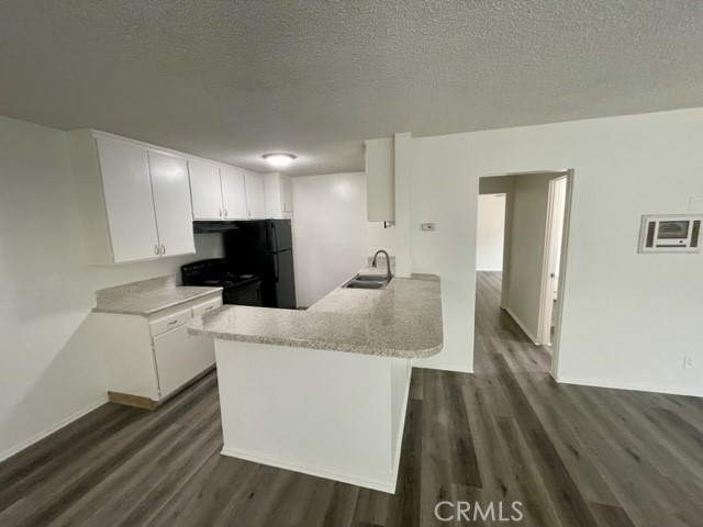 686 East Cottonwood Road, Unit 7 Palm Springs, CA 92262 - Photo 5 of 19 a large white kitchen with wooden floor