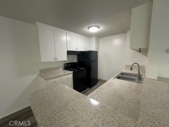 686 East Cottonwood Road, Unit 7 Palm Springs, CA 92262 - Photo 8 of 19 a kitchen with a sink a stove and refrigerator