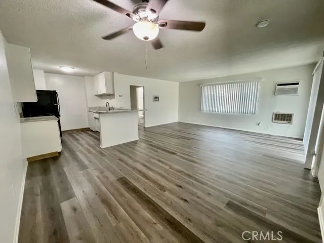 a view of a kitchen with wooden floor and a ceiling fan