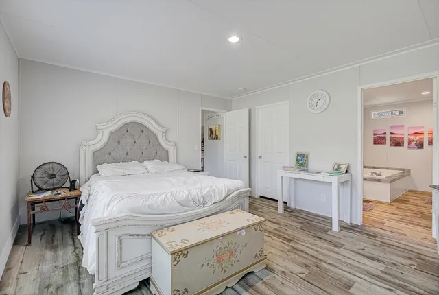 a bedroom with a bed and wooden floor