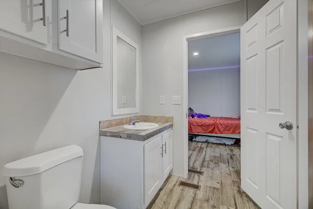a utility room with a sink and wooden floor