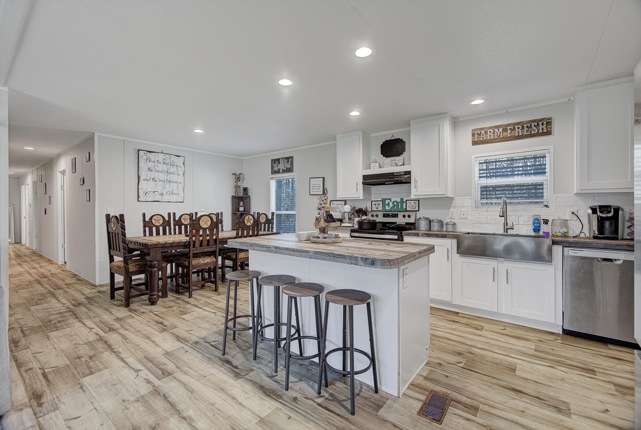 650 County Road 2219 Cleveland, TX 77327 - Photo 8 of 39 a kitchen with stainless steel appliances granite countertop a stove a sink a refrigerator a dining table and chairs with wooden floor