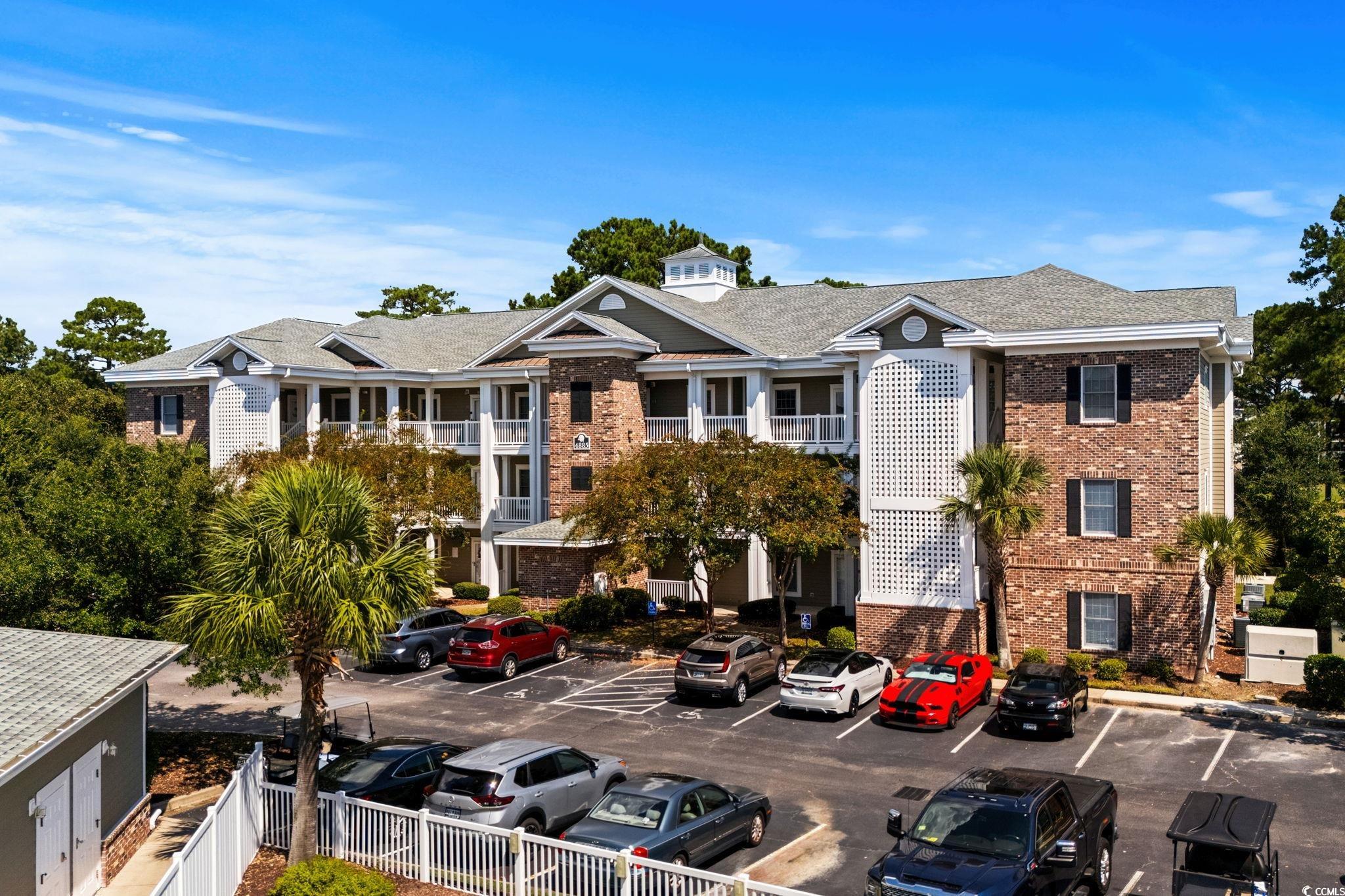 View of building exterior featuring uncovered parking