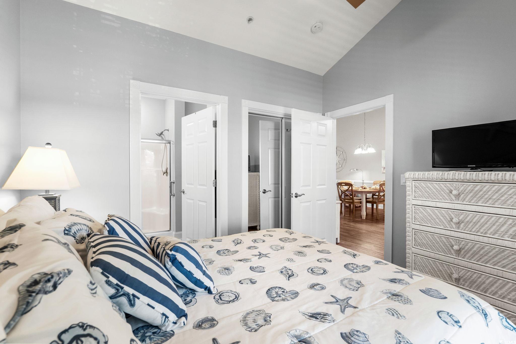 4885 Magnolia Pointe Lane, Unit 304 Myrtle Beach, SC 29577 - Photo 22 of 39 Bedroom featuring ensuite bathroom, wood finished floors, a chandelier, and lofted ceiling