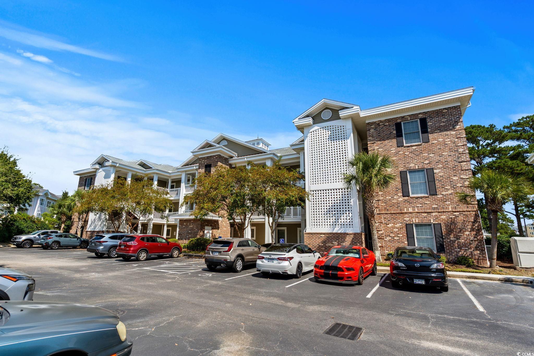 4885 Magnolia Pointe Lane, Unit 304 Myrtle Beach, SC 29577 - Photo 3 of 39 View of building exterior featuring uncovered parking