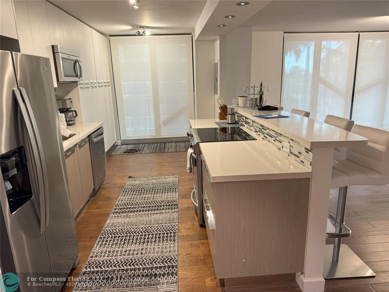 8877 Collins Avenue, Unit 307 Surfside, FL 33154 - Photo 3 of 15 a bathroom with a sink a toilet a mirror and shower