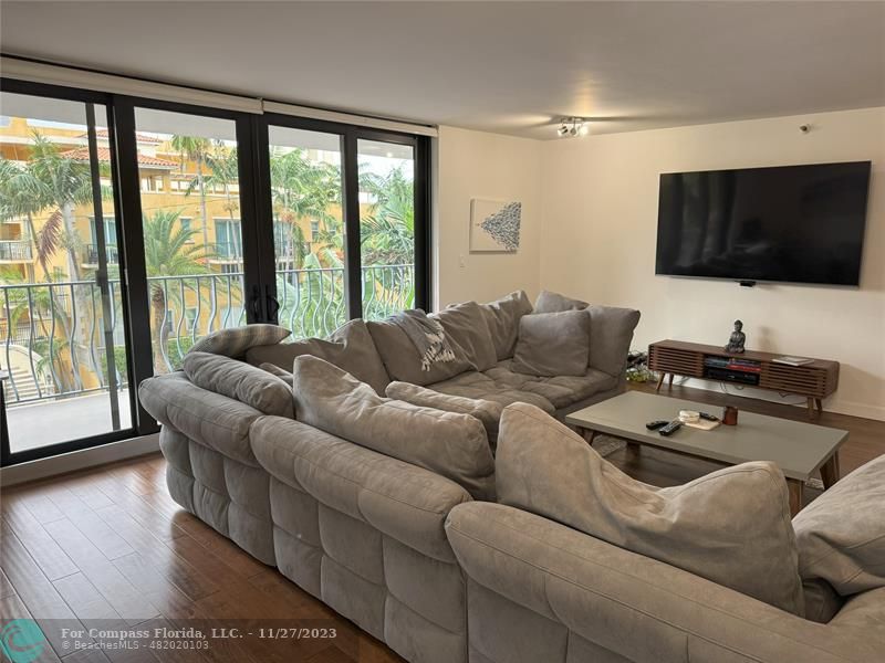 8877 Collins Avenue, Unit 307 Surfside, FL 33154 - Photo 6 of 15 a living room with furniture and a flat screen tv