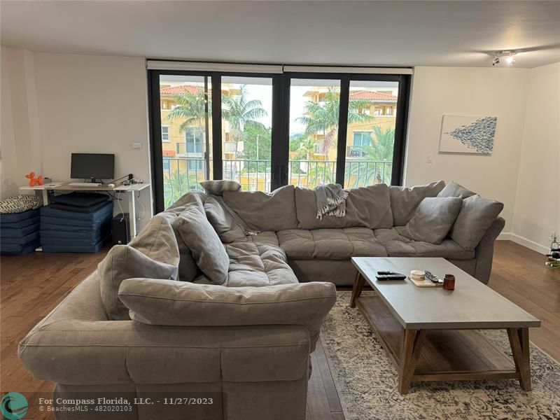 8877 Collins Avenue, Unit 307 Surfside, FL 33154 - Photo 7 of 15 a living room with furniture and a flat screen tv