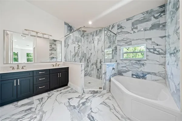a bathroom with a bathtub shower sink vanity and toilet