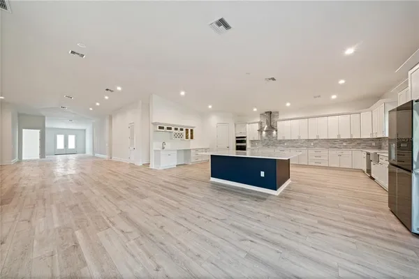 a kitchen with stainless steel appliances granite countertop a large counter top a refrigerator and a sink