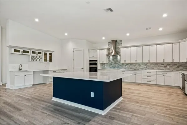 a large kitchen with stainless steel appliances granite countertop a large center island and a stove