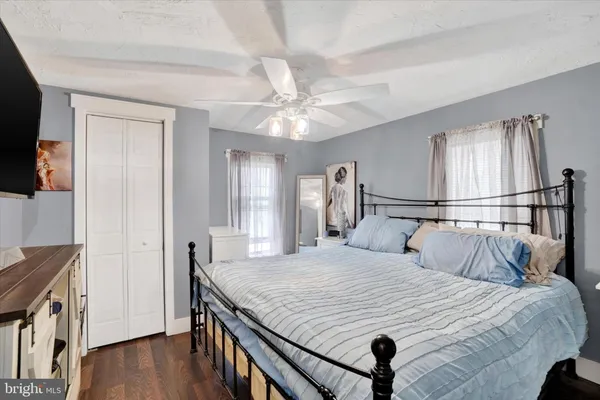 a bedroom with a bed and a flat tv screen on the dresser