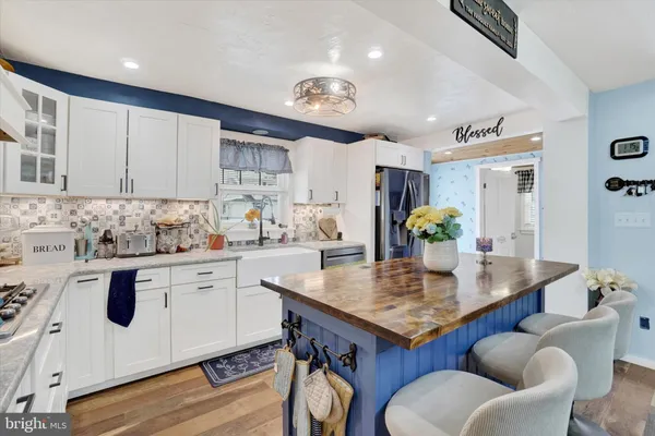 a kitchen with stainless steel appliances granite countertop a table chairs and a refrigerator