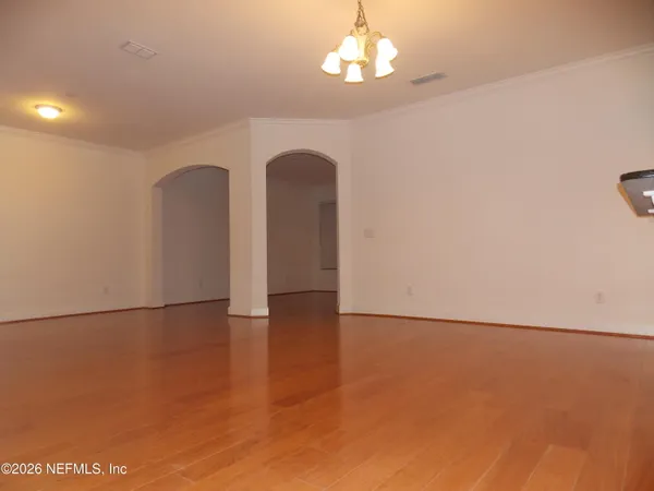 a view of empty room with wooden floor