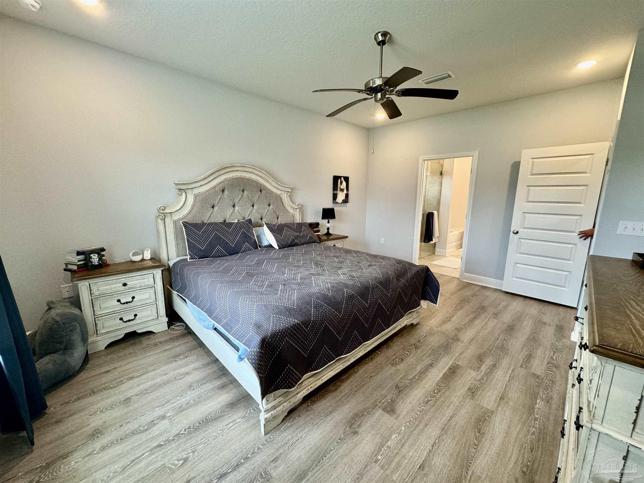 7787 Burnside Loop Pensacola, FL 32526 - Photo 20 of 32 a bedroom with a bed and a chandelier