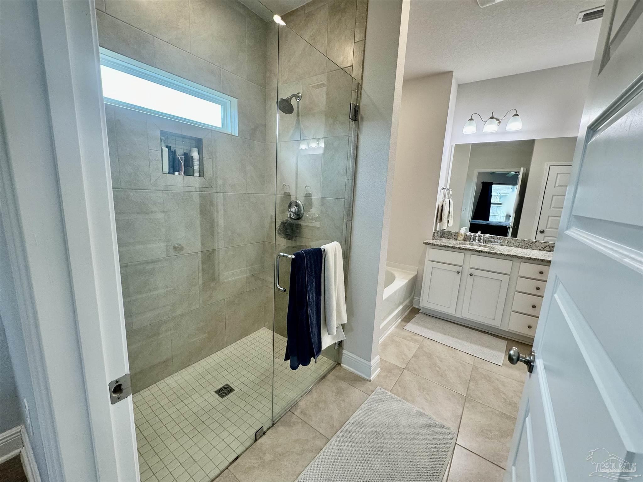 7787 Burnside Loop Pensacola, FL 32526 - Photo 21 of 32 a bathroom with a sink a mirror and a shower