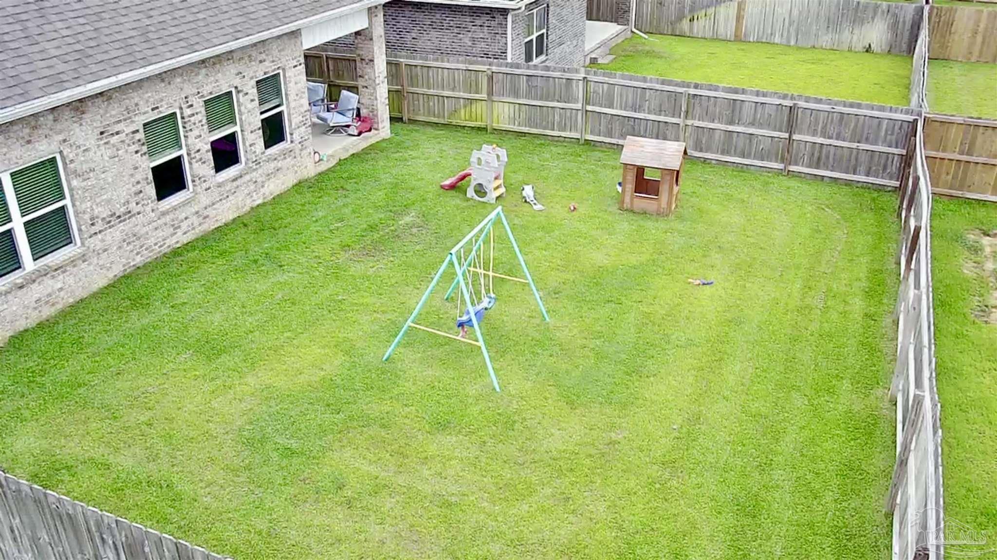 7787 Burnside Loop Pensacola, FL 32526 - Photo 28 of 32 a backyard of a house with lots of green space and plants