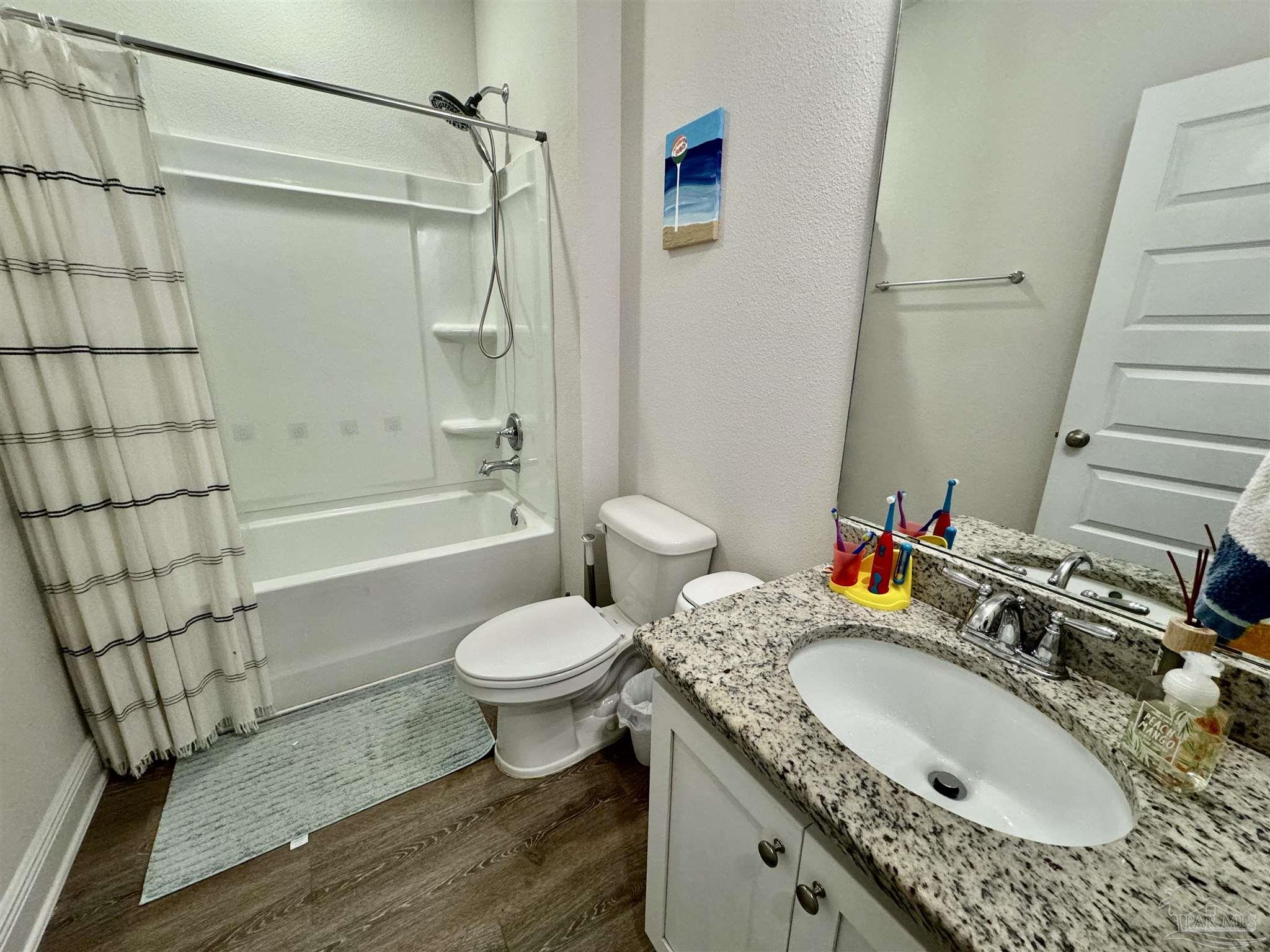 7787 Burnside Loop Pensacola, FL 32526 - Photo 7 of 32 a bathroom with a granite countertop toilet sink and shower