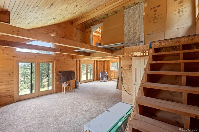 a view of an empty room with a fireplace and windows
