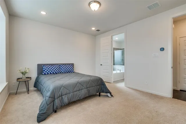 a spacious bedroom with a bed and a lamp