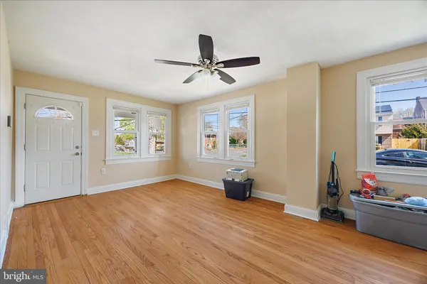 a view of empty room with wooden floor and fan