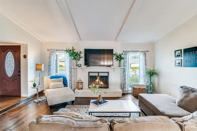 a living room with furniture a fireplace and a flat screen tv