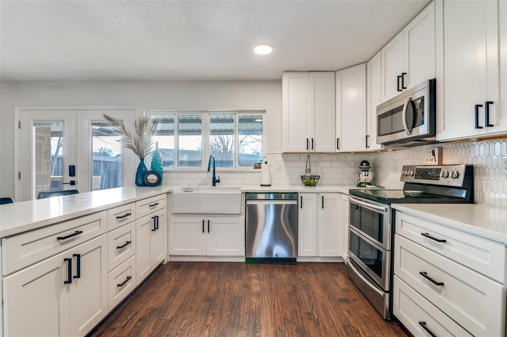 4225 Wayfaring Street Mesquite, TX 75150 - Photo 13 of 26 a kitchen with stainless steel appliances granite countertop white cabinets a sink a stove a window and white cabinets