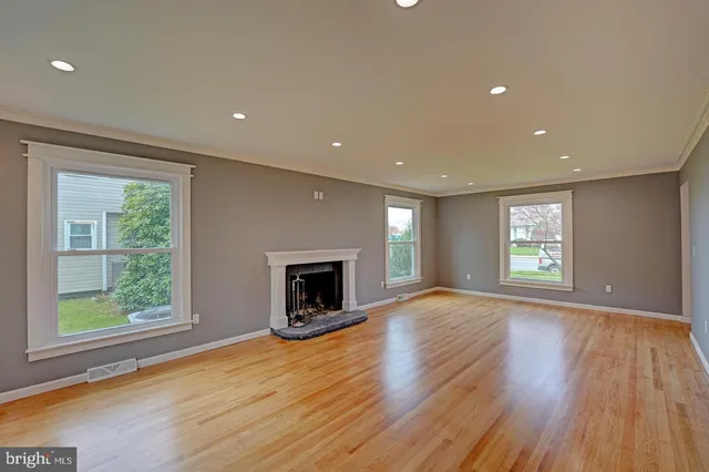 a view of empty room with wooden floor and fireplace