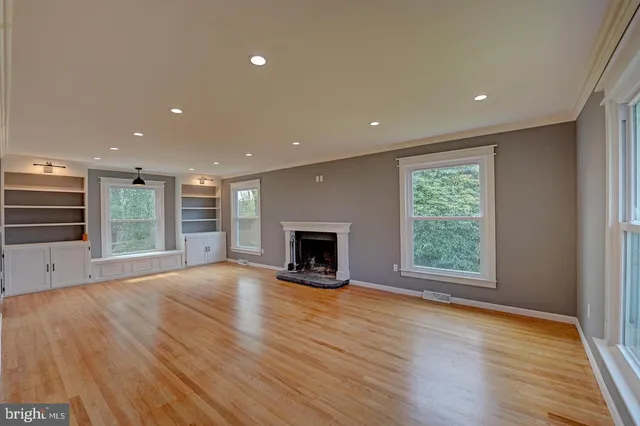 a view of an empty room with a fireplace and a window