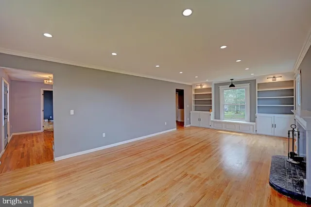 a view of empty room with wooden floor and window
