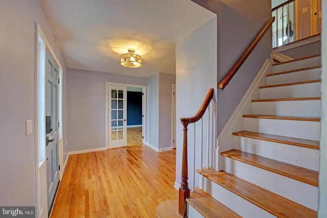 a view of a living room with wooden floor and a chandelier
