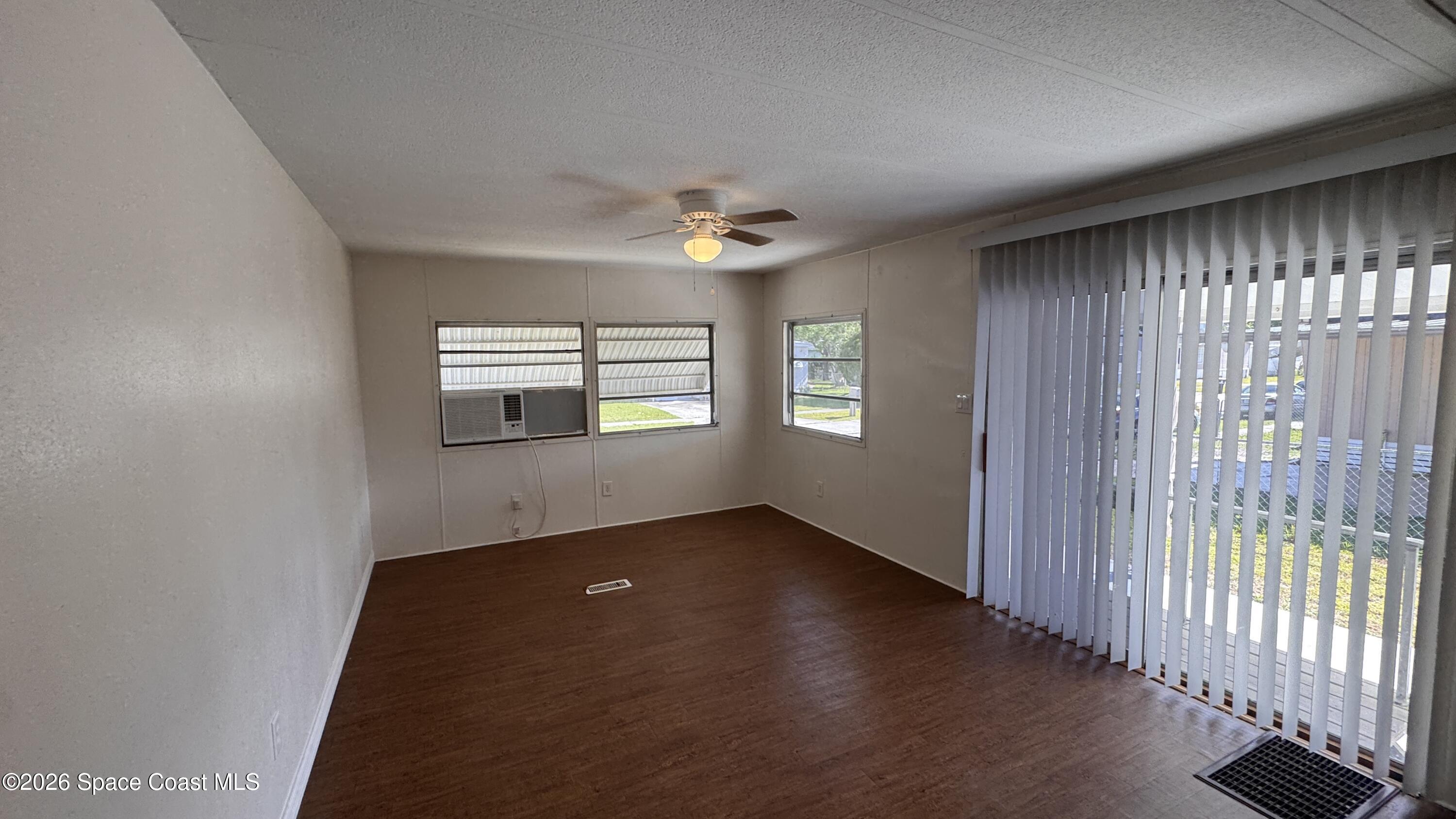 2522 Amberly Road Northeast Palm Bay, FL 32905 - Photo 6 of 13 an empty room with wooden floor chandelier and windows