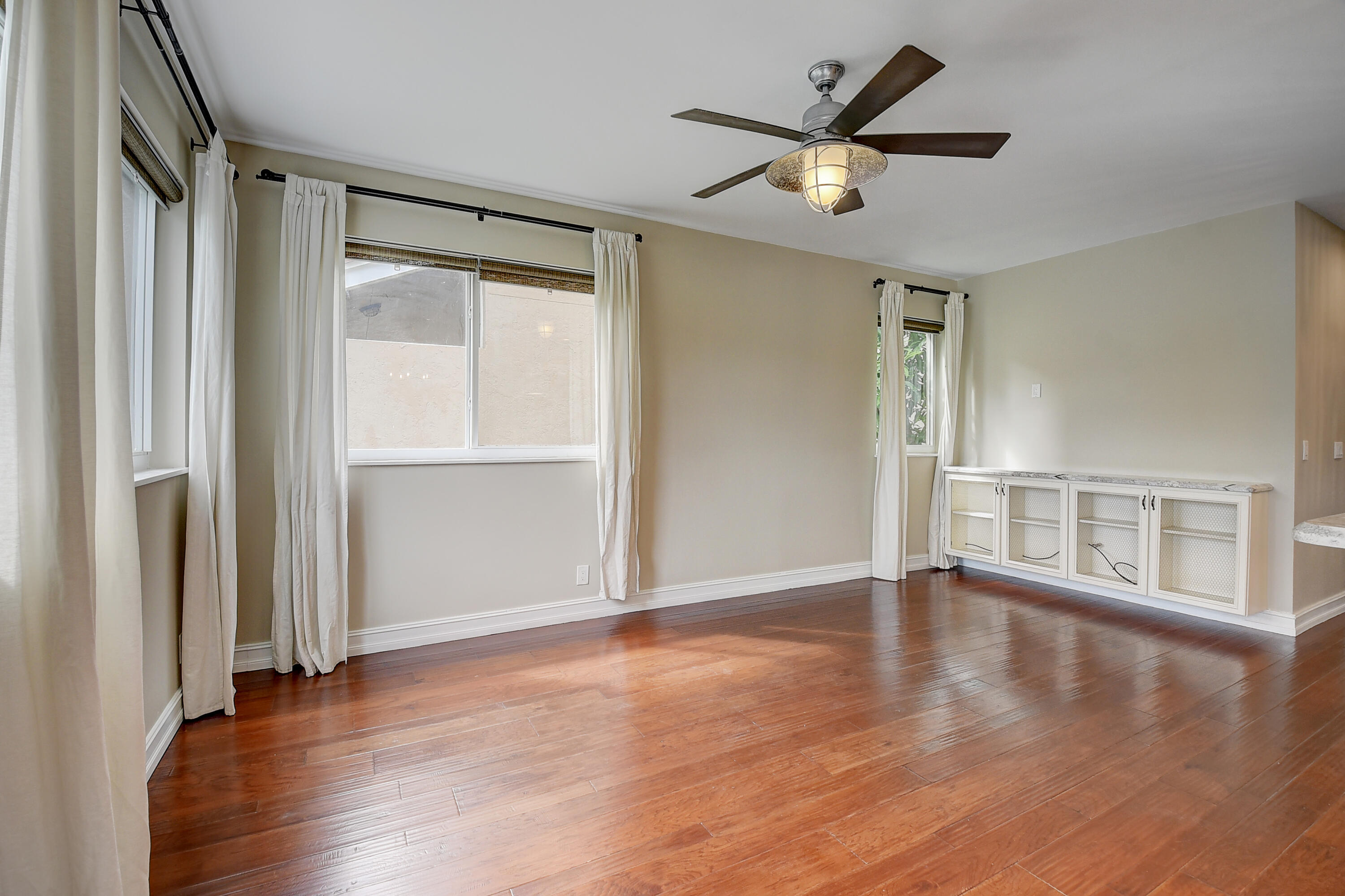 10599 Palm Spring Drive Boca Raton, FL 33428 - Photo 11 of 46 a view of an empty room with wooden floor and a window