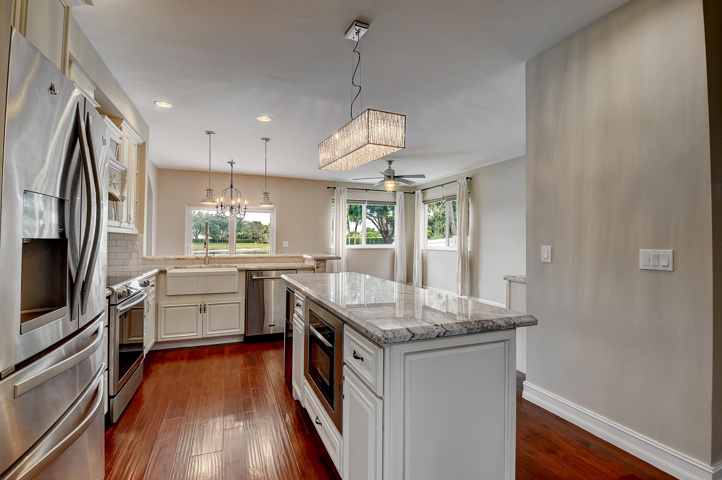 10599 Palm Spring Drive Boca Raton, FL 33428 - Photo 16 of 46 a kitchen with granite countertop a stove oven and wooden floor