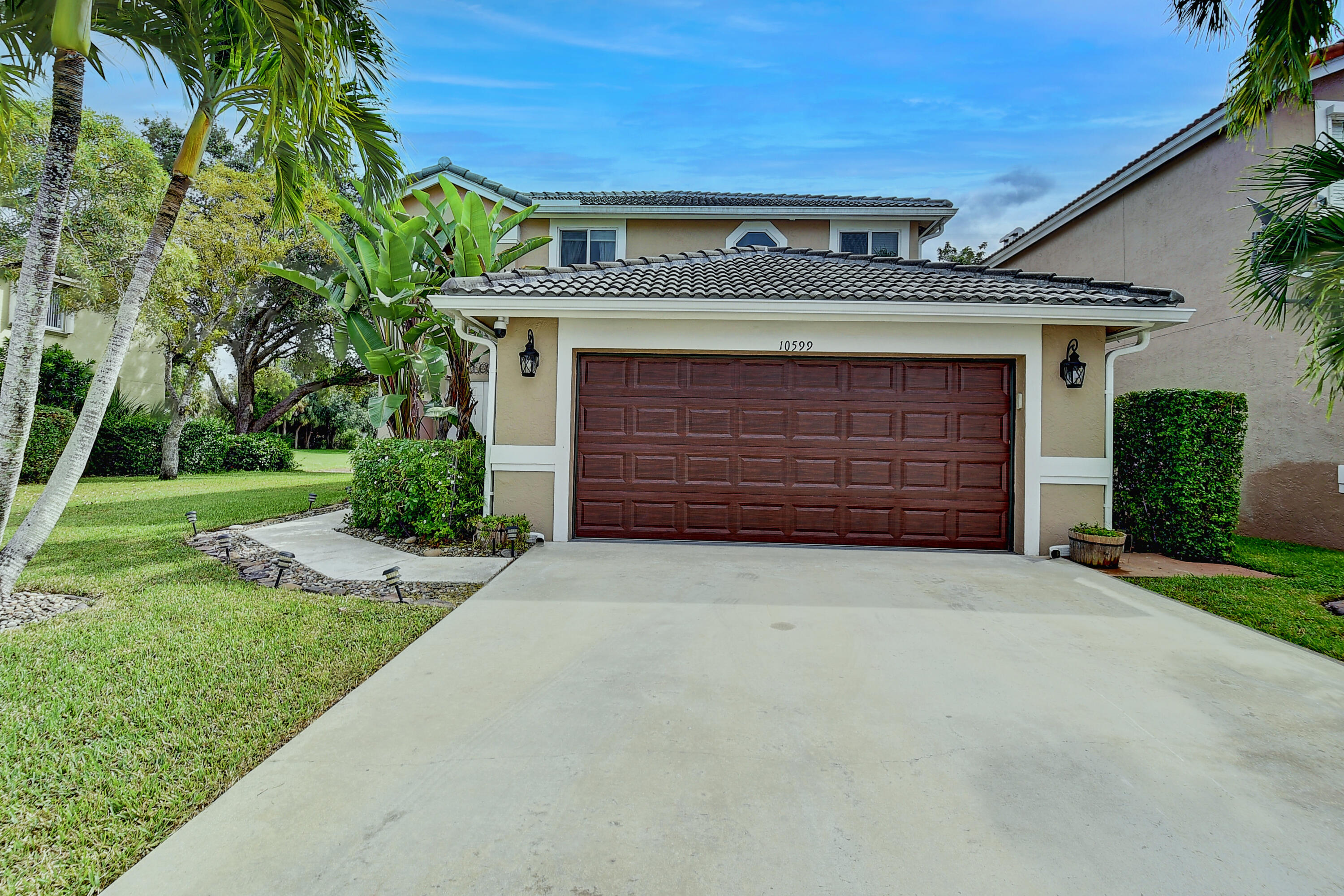 10599 Palm Spring Drive Boca Raton, FL 33428 - Photo 2 of 46 a front view of a house with a yard