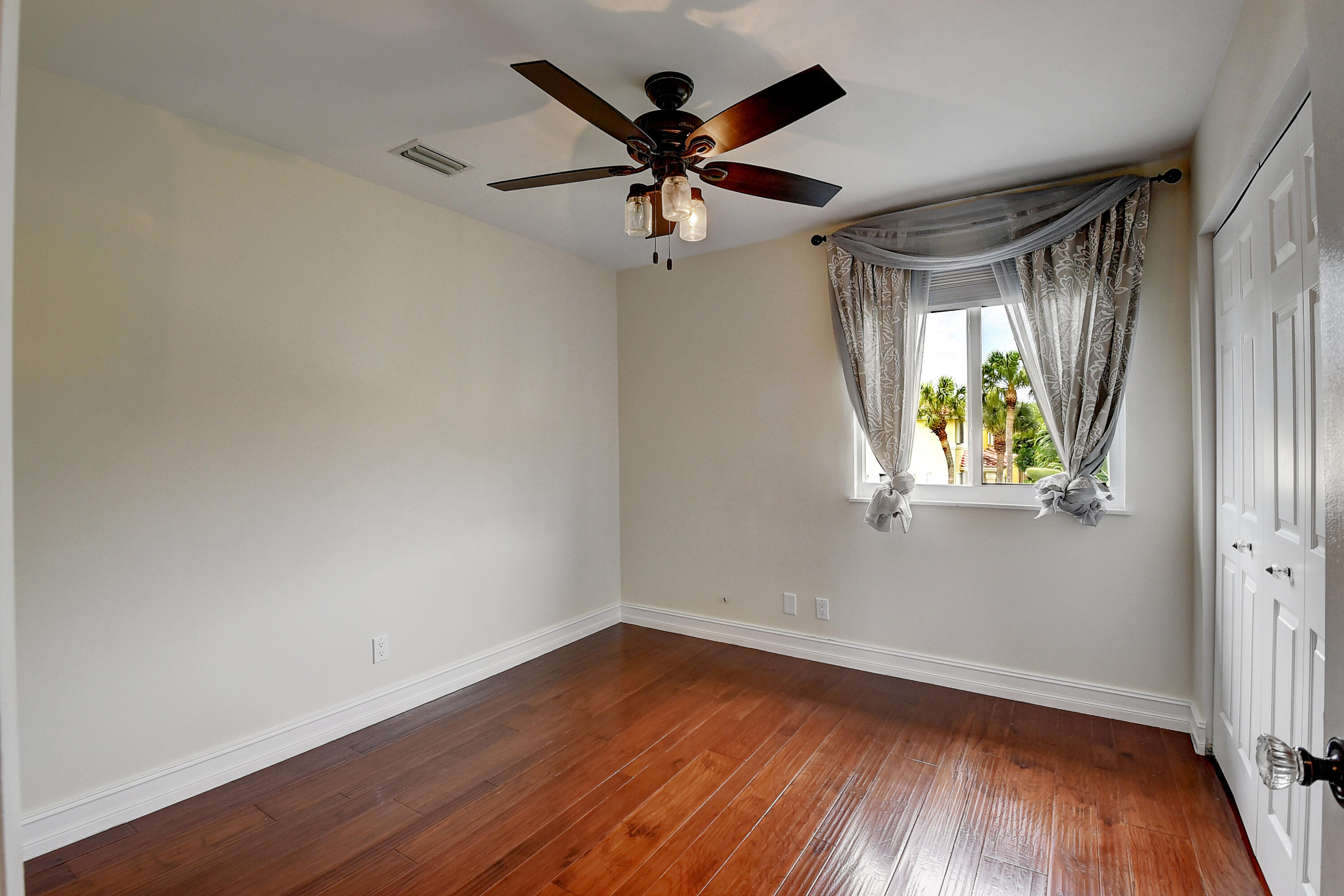 10599 Palm Spring Drive Boca Raton, FL 33428 - Photo 27 of 46 a view of empty room with wooden floor and fan