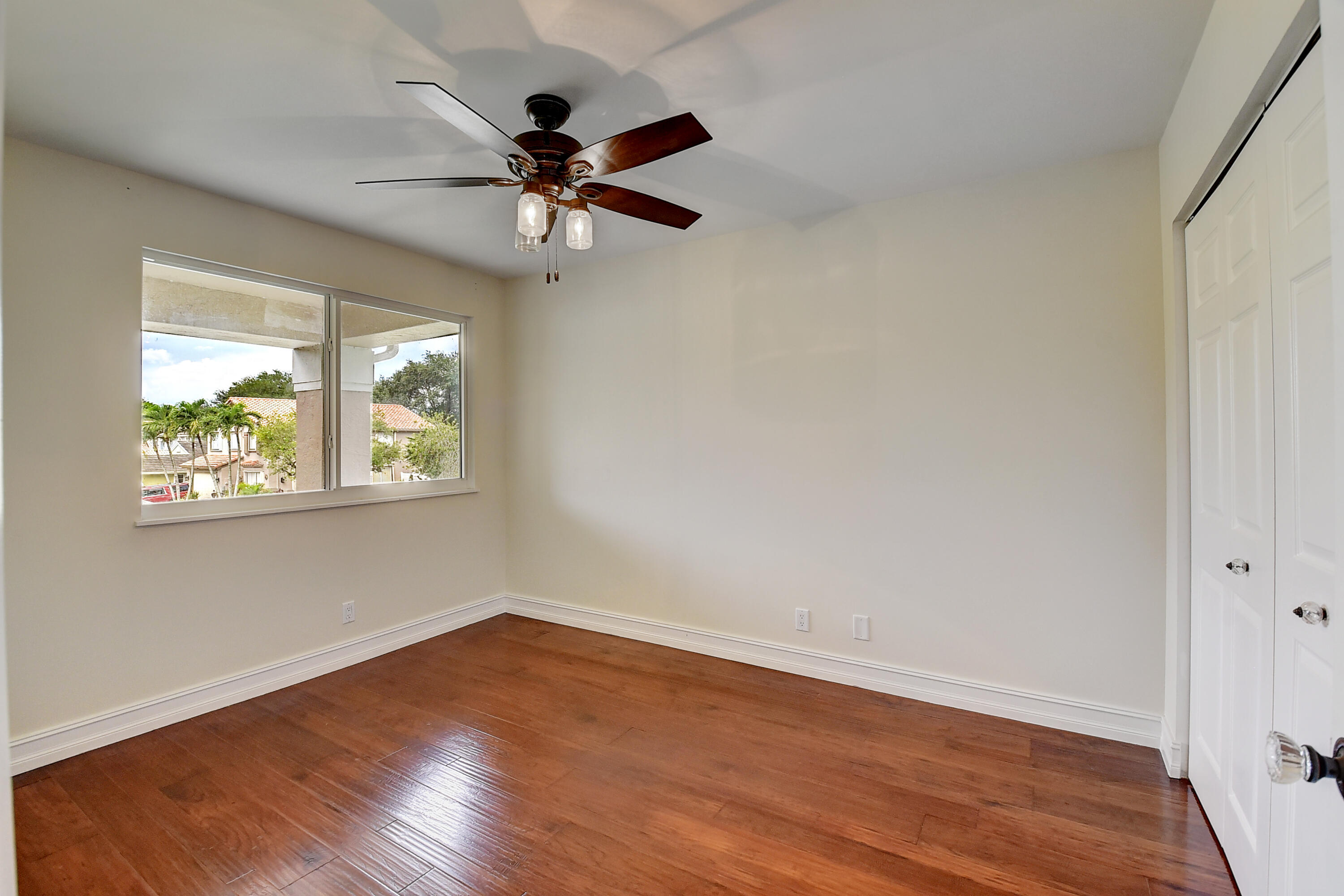10599 Palm Spring Drive Boca Raton, FL 33428 - Photo 28 of 46 a view of an empty room with wooden floor and a window