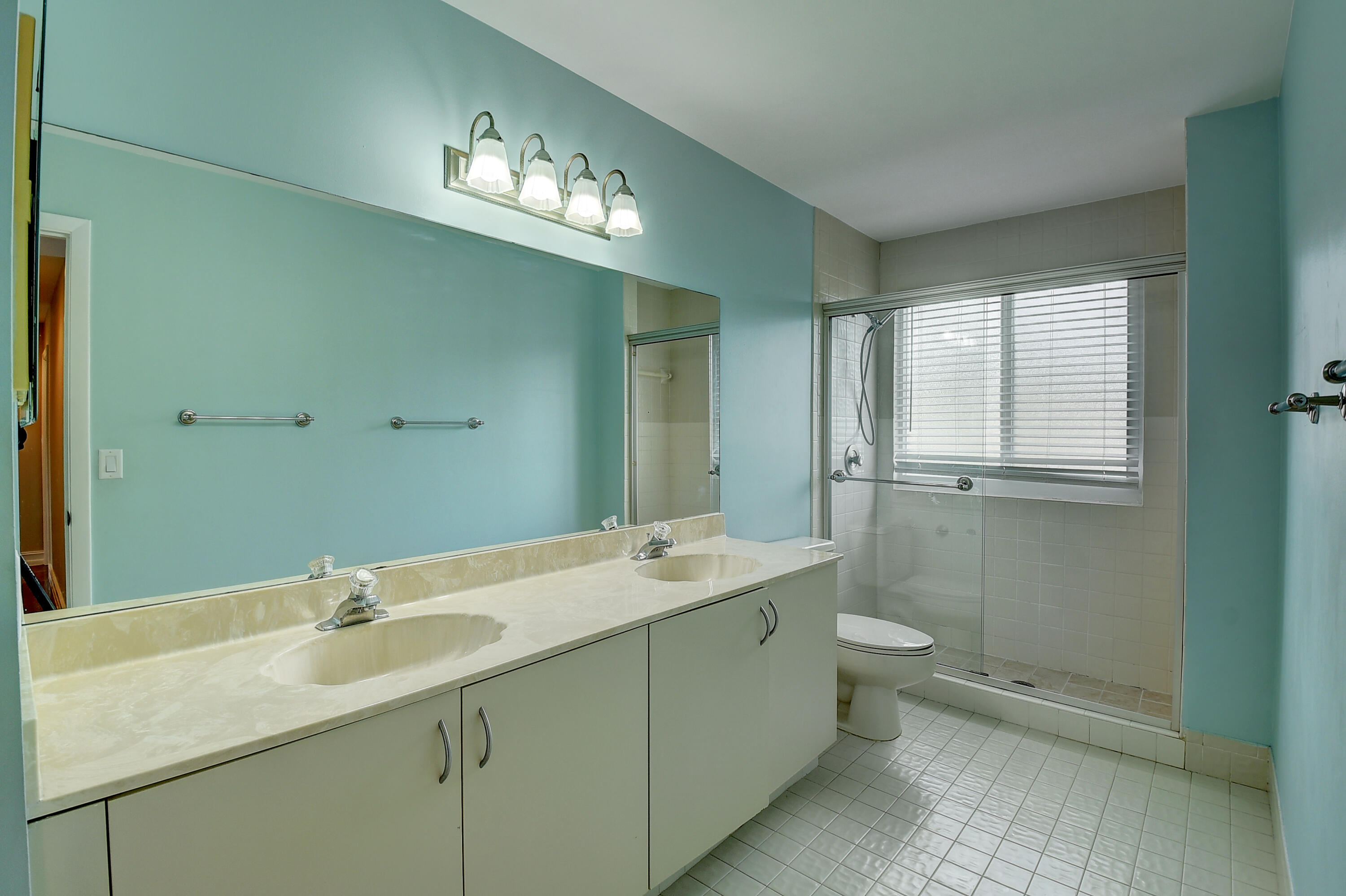 10599 Palm Spring Drive Boca Raton, FL 33428 - Photo 30 of 46 a bathroom with a sink a toilet and a mirror