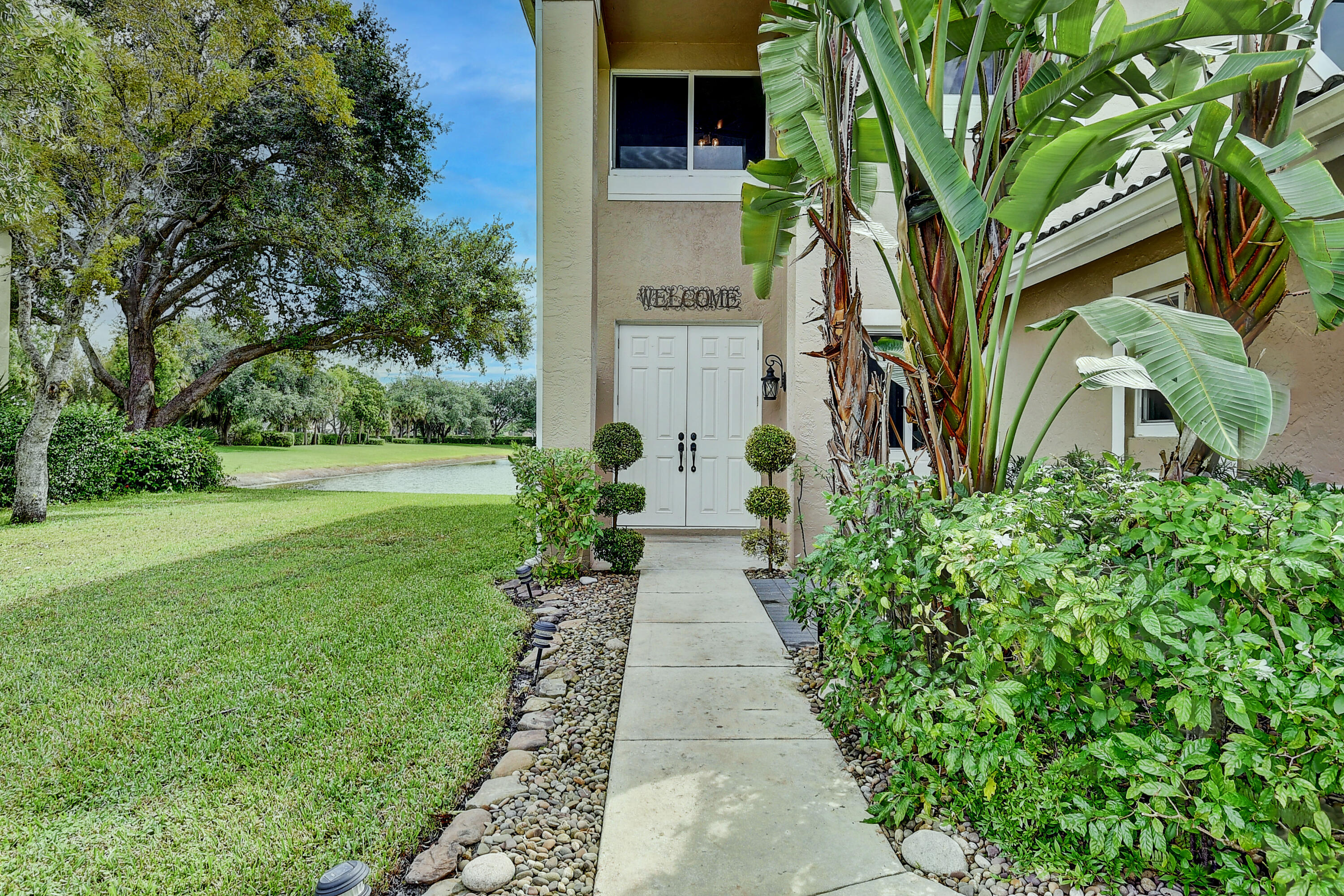 10599 Palm Spring Drive Boca Raton, FL 33428 - Photo 3 of 46 a view of a pathway with a flower garden