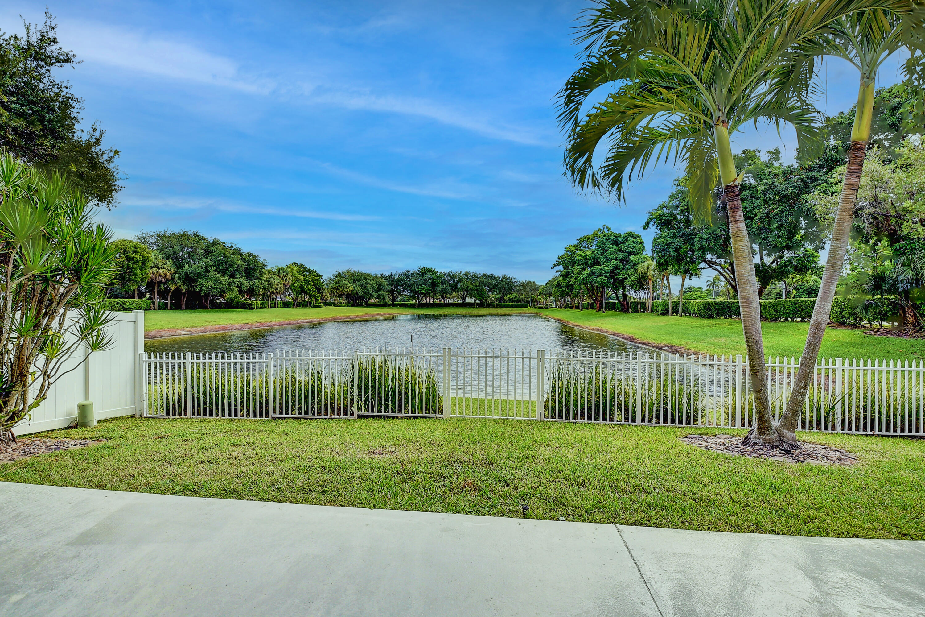10599 Palm Spring Drive Boca Raton, FL 33428 - Photo 31 of 46 a view of a lake with a big yard and large trees