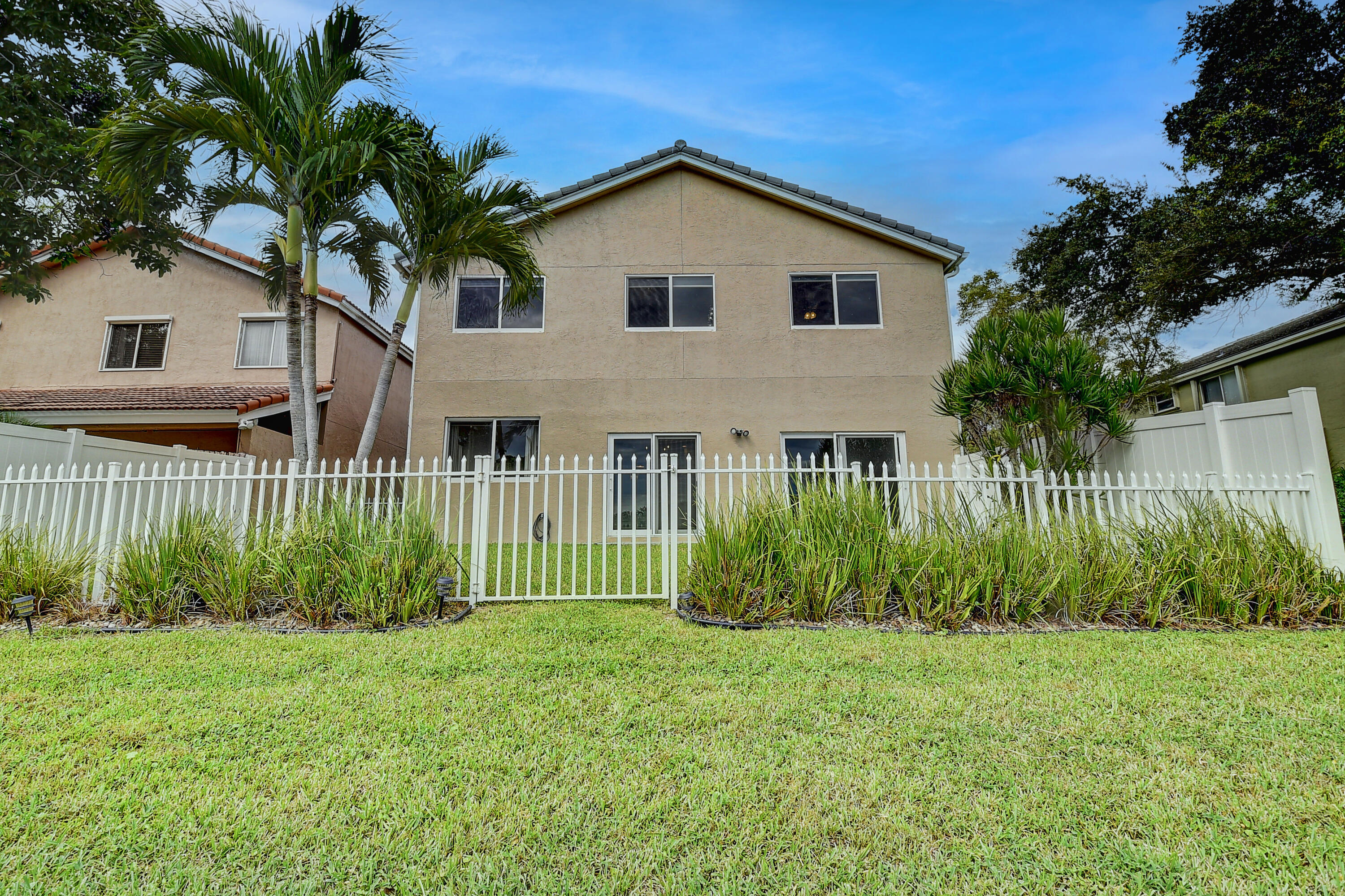 10599 Palm Spring Drive Boca Raton, FL 33428 - Photo 34 of 46 a front view of a house with a garden