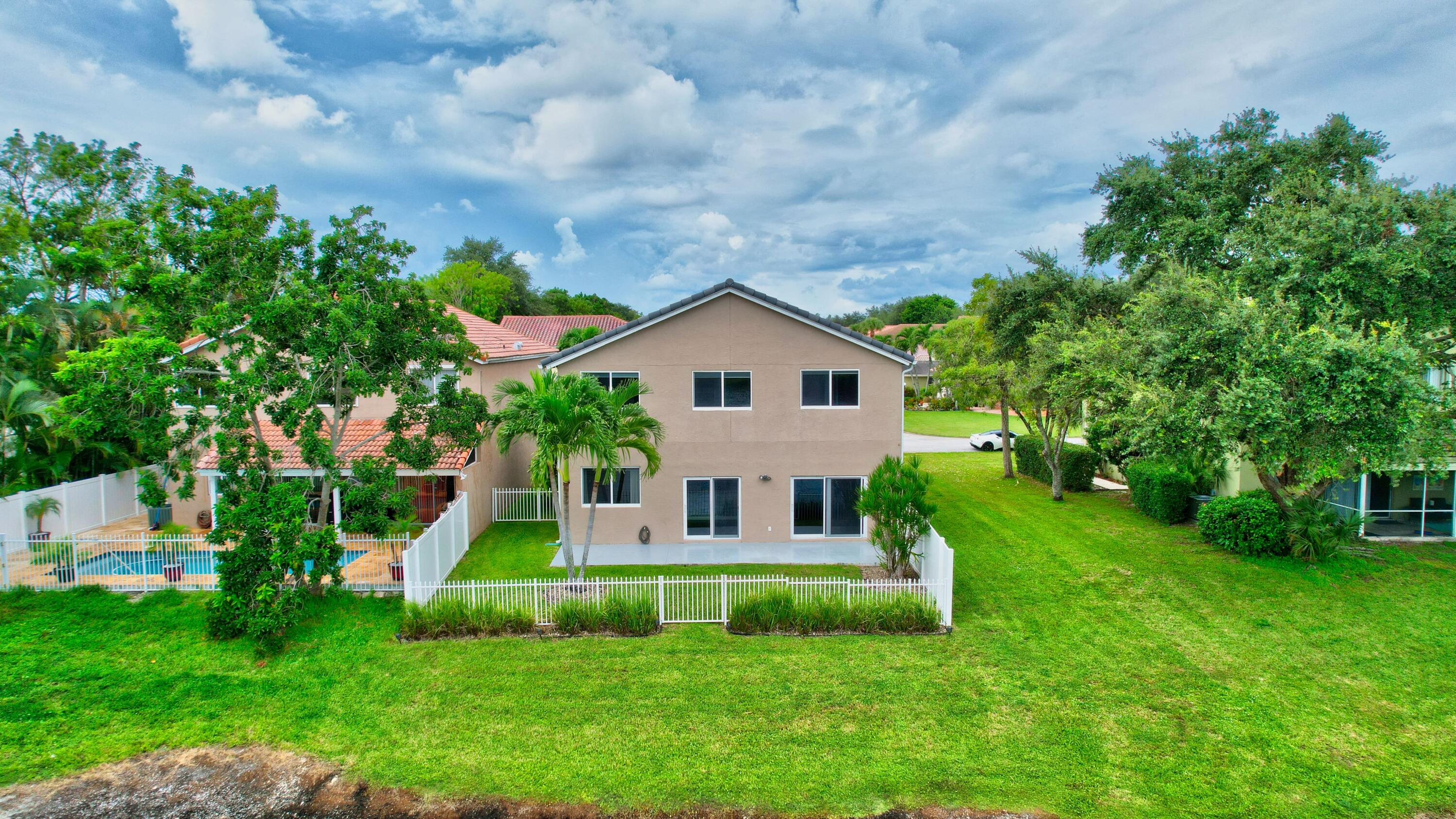 10599 Palm Spring Drive Boca Raton, FL 33428 - Photo 39 of 46 a front view of a house with a yard and green space