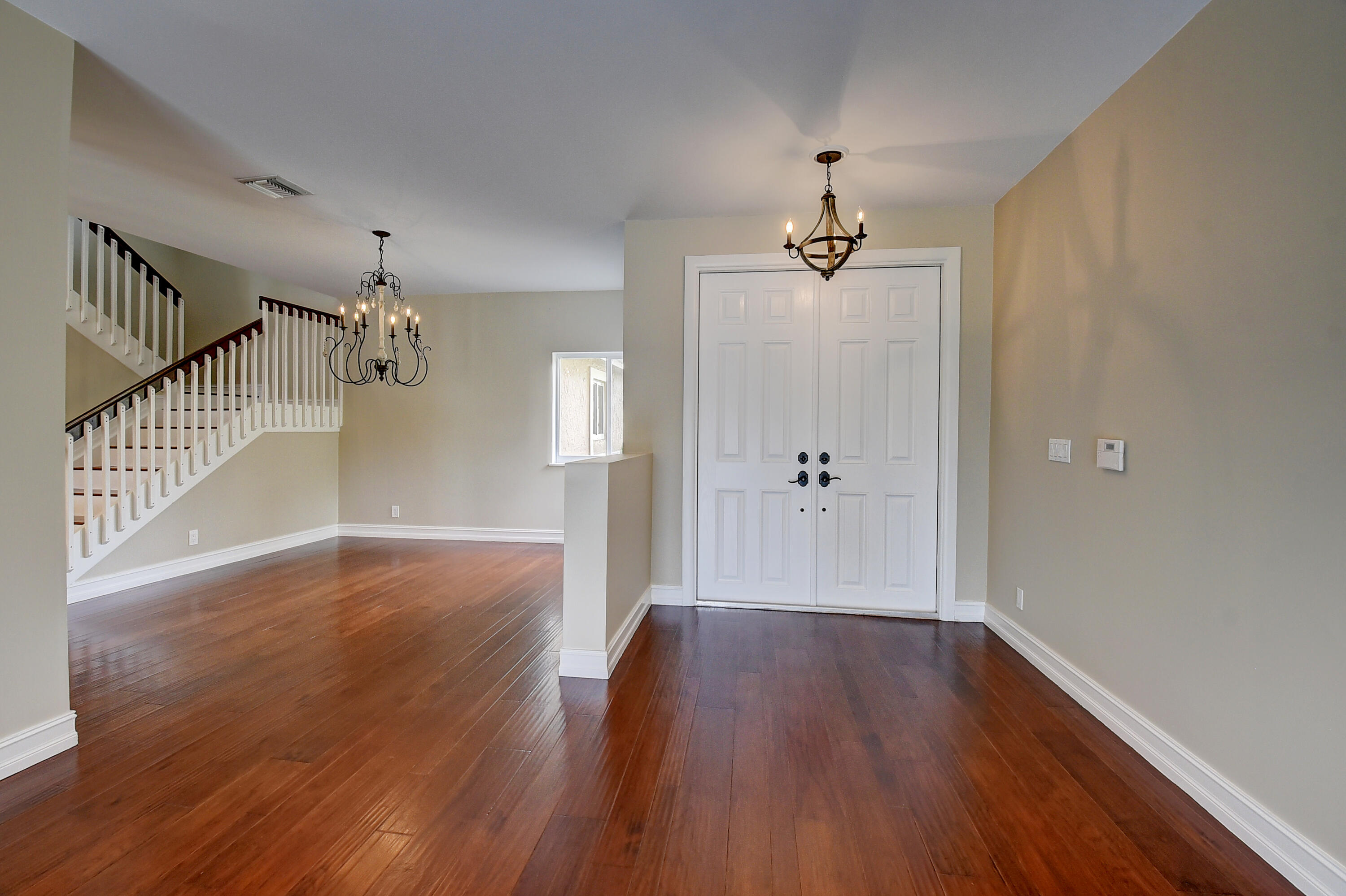 10599 Palm Spring Drive Boca Raton, FL 33428 - Photo 4 of 46 a view of a hallway with wooden floor and staircase