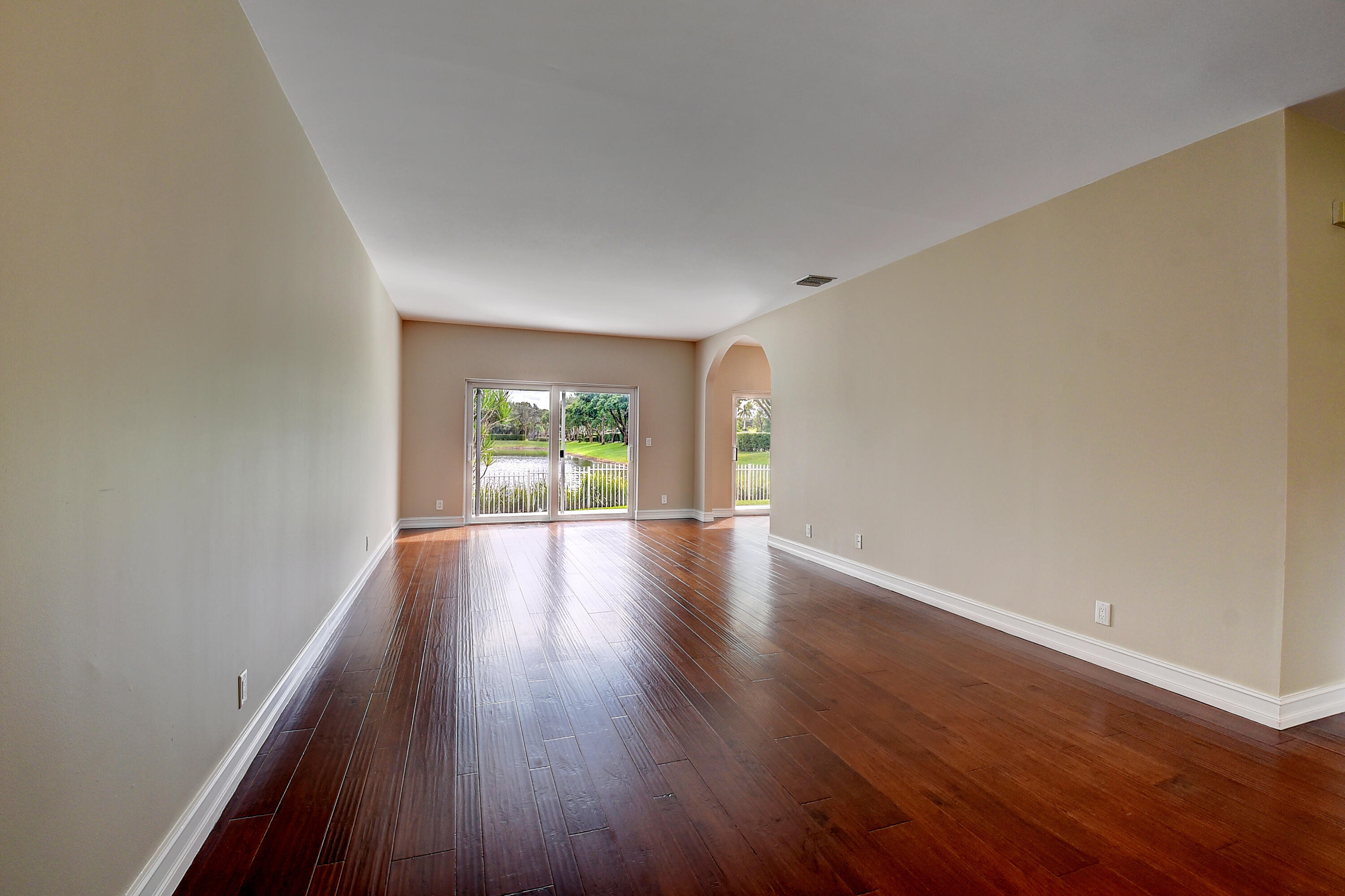 10599 Palm Spring Drive Boca Raton, FL 33428 - Photo 5 of 46 a view of an empty room with wooden floor and windows